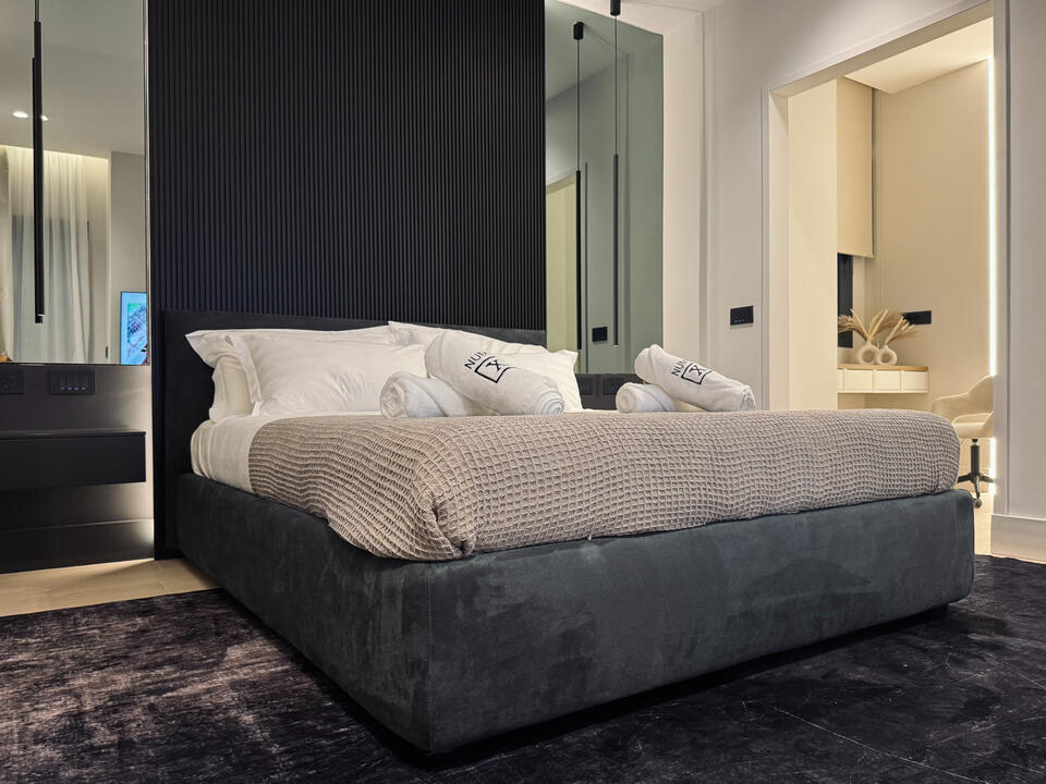 Huge designer Bedroom with big TV, walk-in closet, and vanity/workspace
